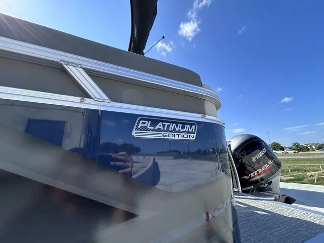 Slide: The Image of 2024 Avalon Venture Quad Lounger 23 FT, Platinum Edition, with Yamaha motor, under clear blue sky. - 12