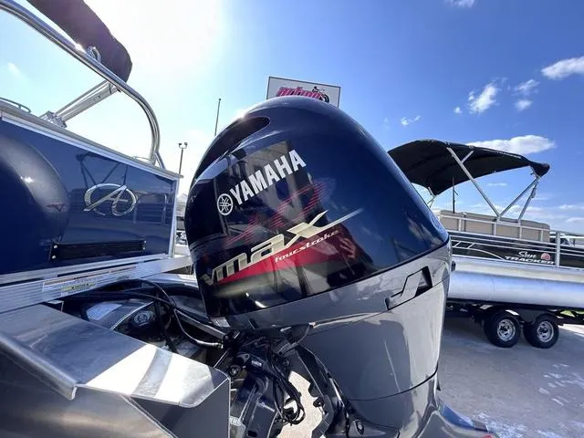 Slide: The Image of 2024 Avalon Venture Quad Lounger with Yamaha VMAX outboard motor under a clear blue sky. - 13