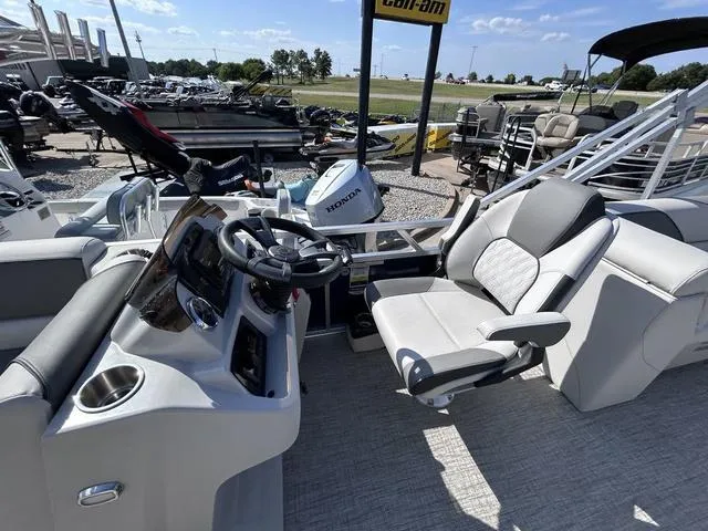Slide: The Image of 2024 Avalon Venture Quad Lounger 23 FT boat interior with steering console and seating. - 6