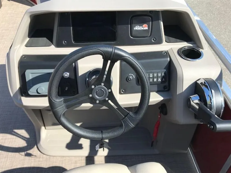 Slide: The Image of 2024 Sun Tracker PB 22 DLX boat steering console with controls and cup holder. - 8