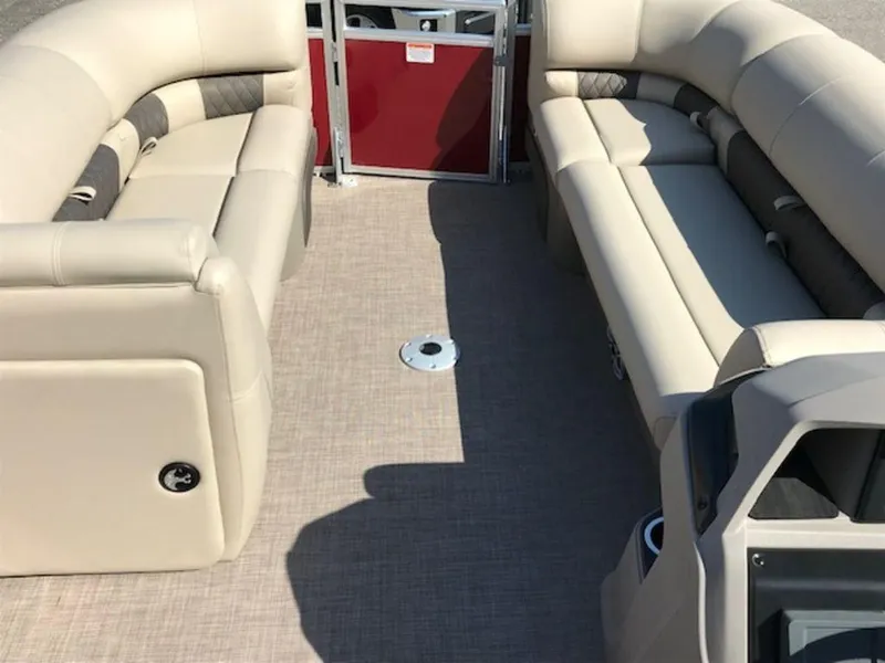 Slide: The Image of 2024 Sun Tracker PB 22 DLX pontoon boat interior with beige seating and red door. - 9