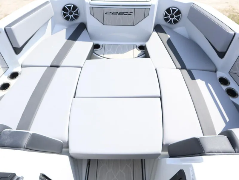 Slide: The Image of 2024 Yamaha Boats 222XE interior seating area with cushioned seats and cup holders. - 5