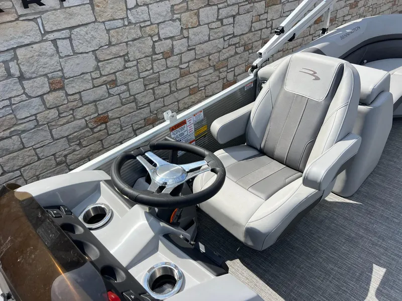 Slide: The Image of 2024 Bennington 22S boat helm with gray captain's chair and steering wheel. - 11