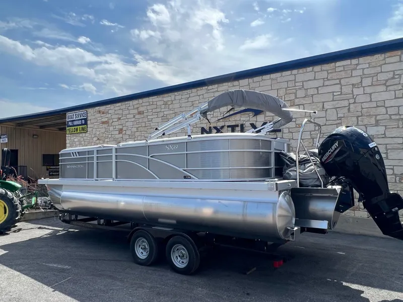 Slide: The Image of 2024 Bennington 22S pontoon boat on trailer, parked outside service center. - 5