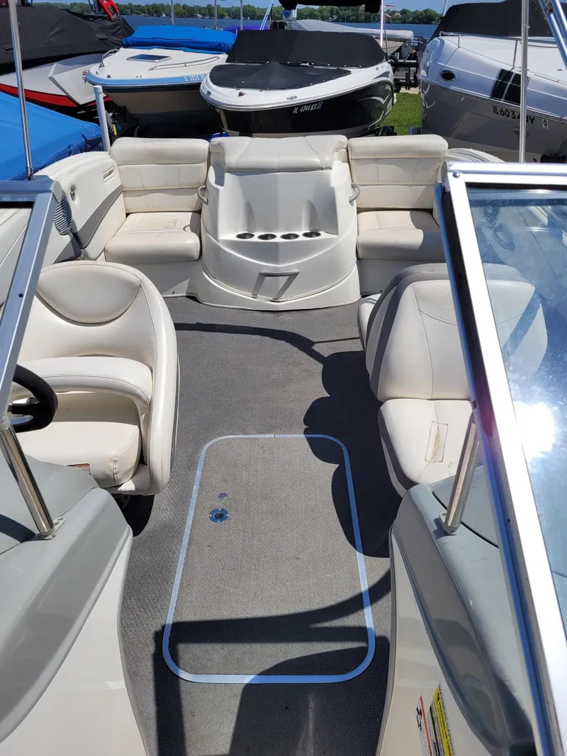 Slide: The Image of Interior of a 2008 Bayliner 205 boat with white seating and carpeted floor. - 14