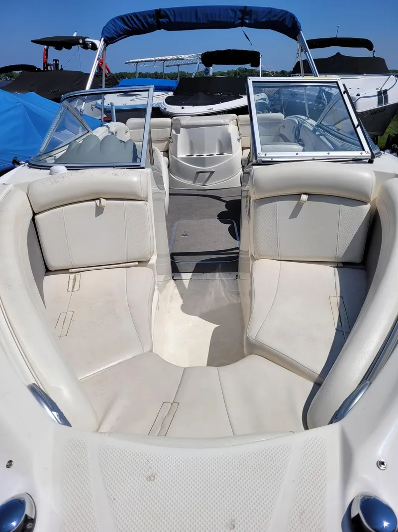 Slide: The Image of 2008 Bayliner 205 boat interior with white seating and blue canopy. - 18