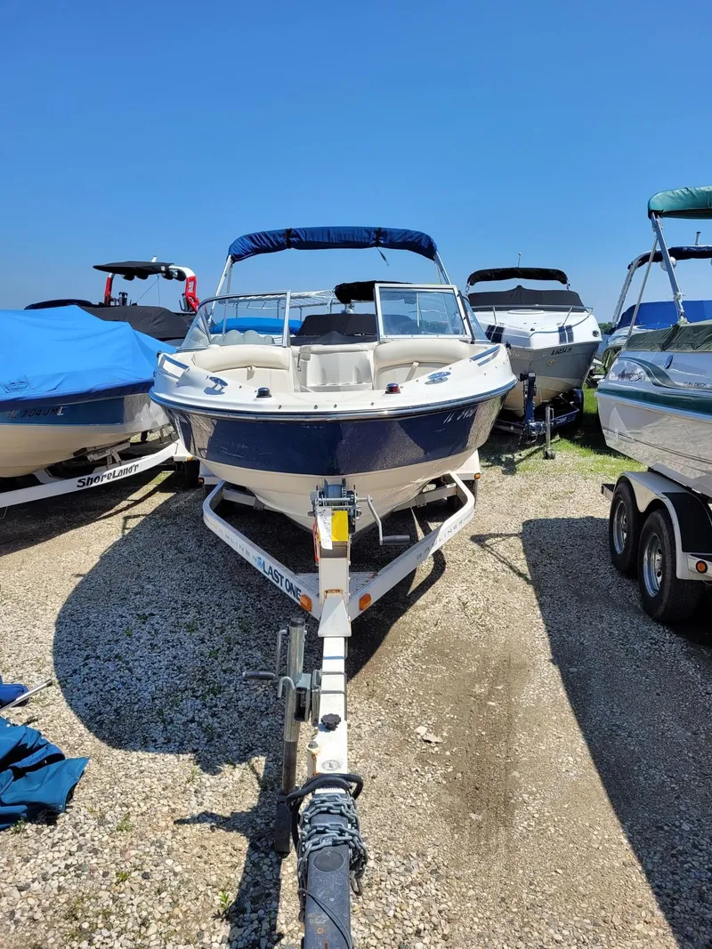 Slide: The Image of 2008 Bayliner 205 boat on trailer, parked among other boats under clear blue sky. - 19
