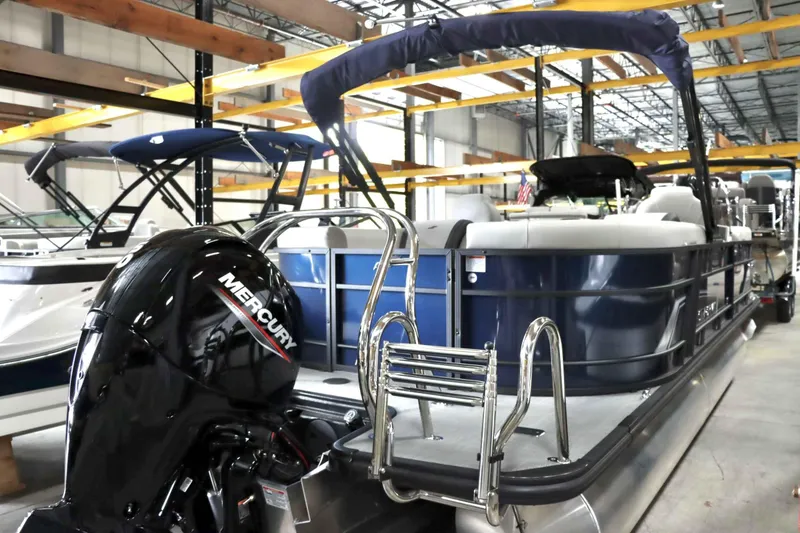 Slide: The Image of 2025 Starcraft EXS 3 pontoon boat with Mercury outboard engine in showroom. - 5