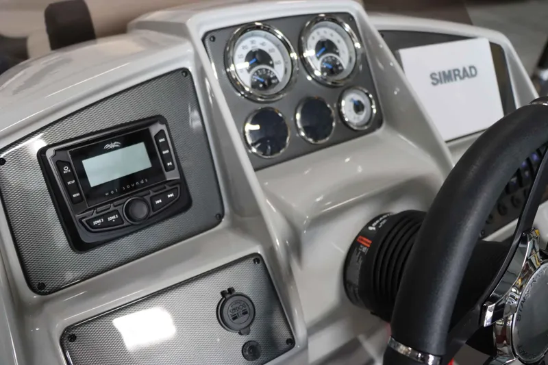 Slide: The Image of 2025 Starcraft EXS 3 boat dashboard with Simrad display and audio controls. - 18