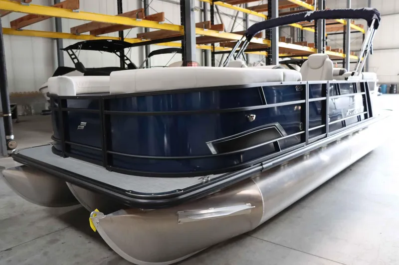 Slide: The Image of 2025 Starcraft EXS 3 pontoon boat in warehouse, blue exterior, white seating. - 8