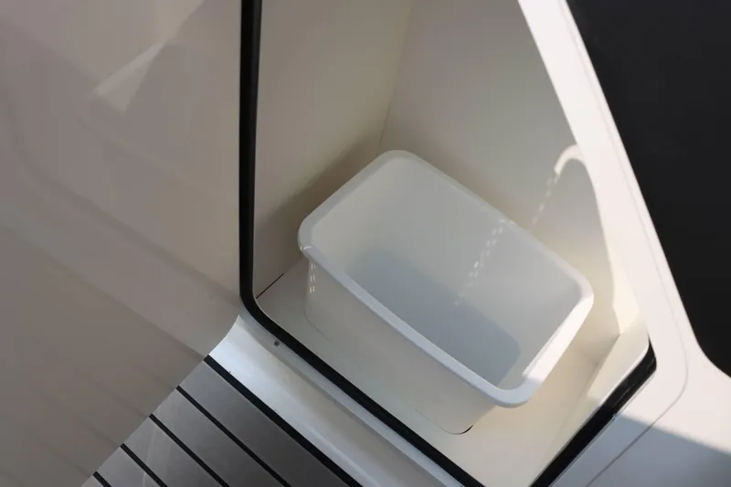 Slide: The Image of 2024 Sea Ray 280SLX interior storage compartment with white container. - 25