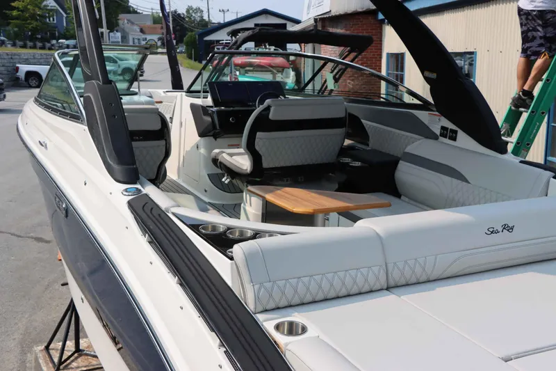 Slide: The Image of 2024 Sea Ray 280SLX luxury boat interior with white seating and wooden table. - 7