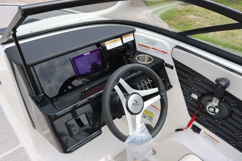 Slide: The Image of 2025 Sea Ray 210SPX boat dashboard with steering wheel and control panel. - 17