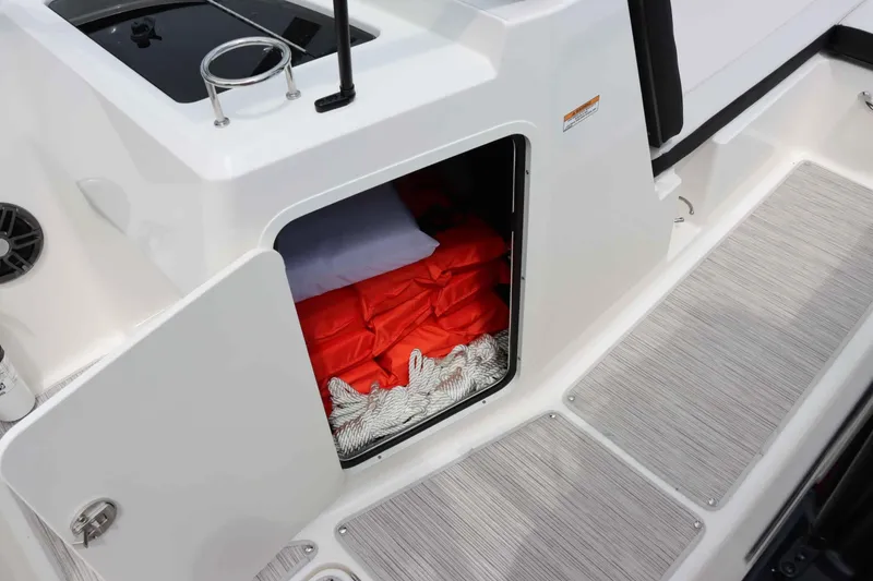 Slide: The Image of 2025 Sea Ray 210SPX boat storage compartment with life jackets and rope. - 19
