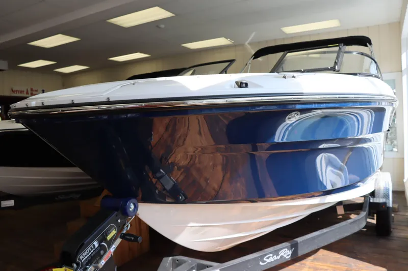 Slide: The Image of 2025 Sea Ray 210SPX boat displayed indoors on a trailer. - 6