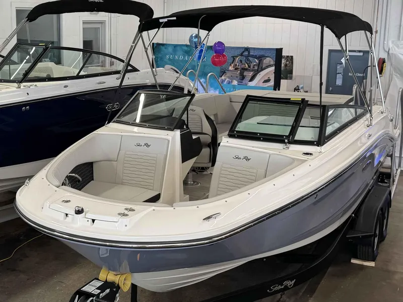 Slide: The Image of 2024 Sea Ray 230SPX boat with sleek design in showroom display. - 21