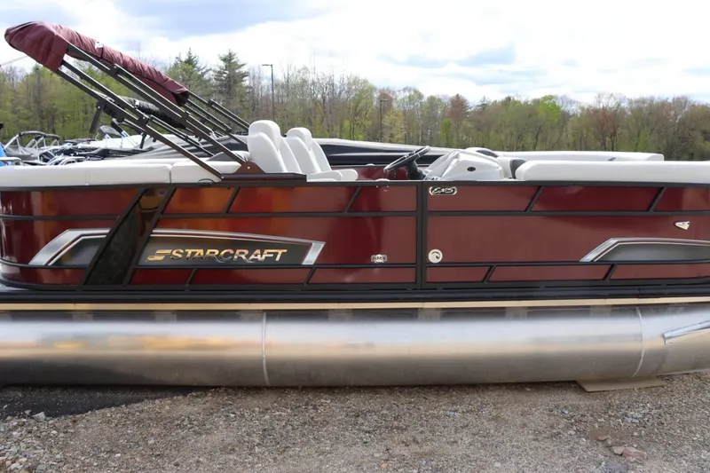 Slide: The Image of 2024 Starcraft EXS 3 pontoon boat with maroon exterior and white seating. - 2