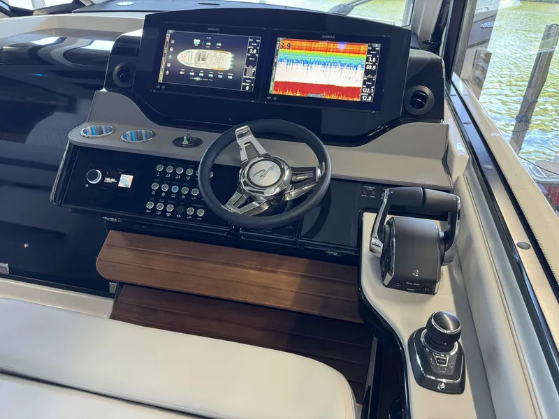 Slide: The Image of 2024 Sea Ray 370 Sundancer helm with advanced navigation and control systems. - 11