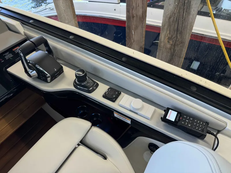Slide: The Image of 2024 Sea Ray 370 Sundancer helm with controls and communication equipment. - 12