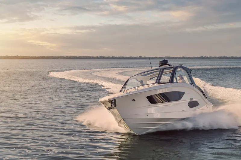 Slide: The Image of 2024 Sea Ray 370 Sundancer cruising on open water at sunset. - 16