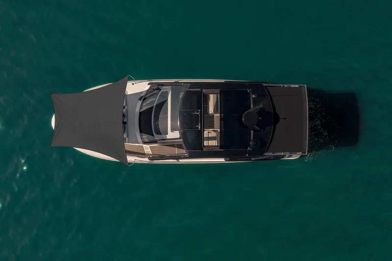 Slide: The Image of Top view of 2024 Sea Ray 370 Sundancer yacht cruising on clear blue water. - 18