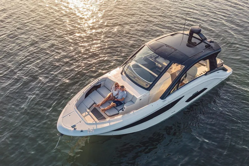 Slide: The Image of 2024 Sea Ray 370 Sundancer cruising on calm water at sunset. - 23