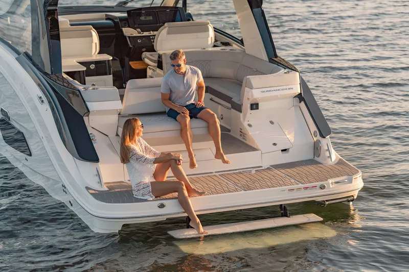 Slide: The Image of 2024 Sea Ray 370 Sundancer with people relaxing on the deck at sunset. - 25
