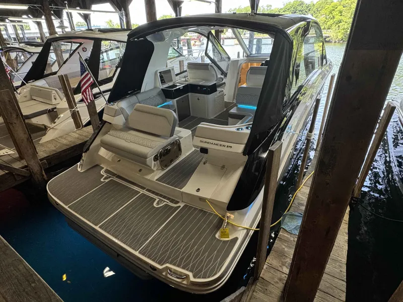 Slide: The Image of 2024 Sea Ray 370 Sundancer docked, showcasing sleek design and spacious seating area. - 3