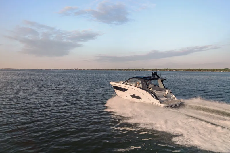 Slide: The Image of 2024 Sea Ray 370 Sundancer cruising on open water at sunset. - 36