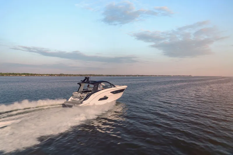 Slide: The Image of 2024 Sea Ray 370 Sundancer cruising on open water at sunset. - 39