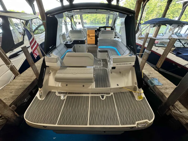 Slide: The Image of 2024 Sea Ray 370 Sundancer boat with spacious deck and modern seating in marina. - 4