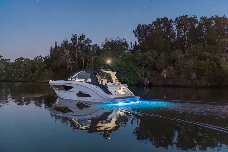 Slide: The Image of 2024 Sea Ray 370 Sundancer yacht cruising at night with underwater lights. - 40