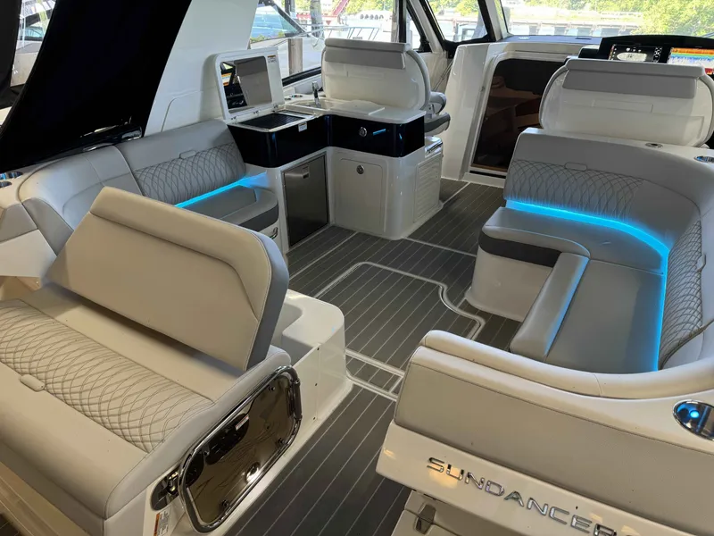 Slide: The Image of 2024 Sea Ray 370 Sundancer interior with modern seating and ambient lighting. - 9