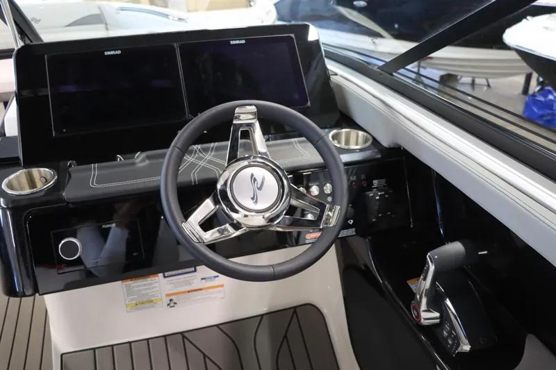 Slide: The Image of 2024 Sea Ray 280SLX boat helm with dual Simrad displays and modern steering wheel. - 18