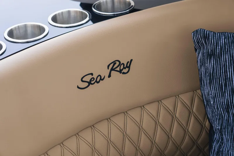 Slide: The Image of Close-up of 2024 Sea Ray 260SXS boat's beige leather seating with logo. - 11