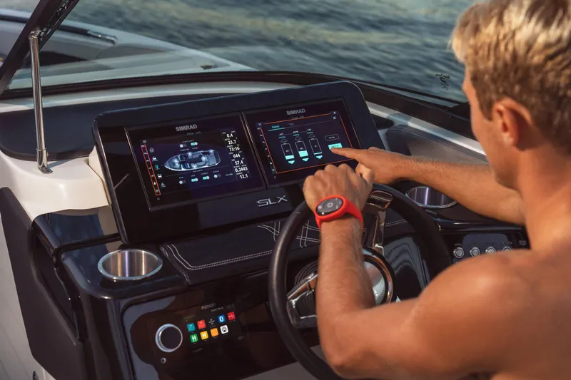 Slide: The Image of Man operating the advanced touchscreen controls of a 2024 Sea Ray 260SXS boat. - 13