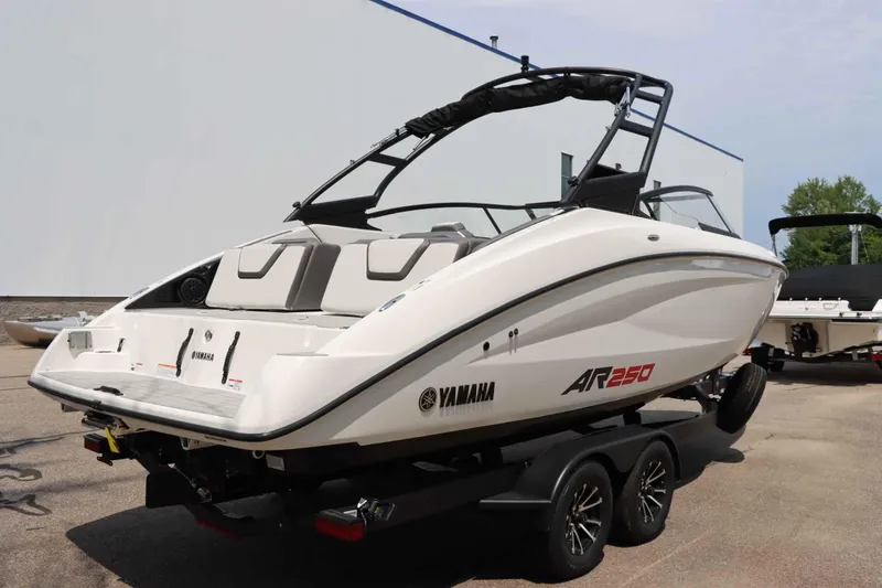 Slide: The Image of 2024 Yamaha AR250 boat on trailer, sleek design, white exterior, dual axles. - 7