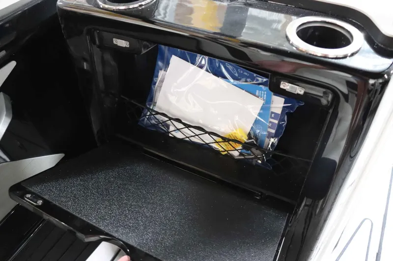 Slide: The Image of 2024 Yamaha Boats 222SD storage compartment with cup holders and netted storage. - 20