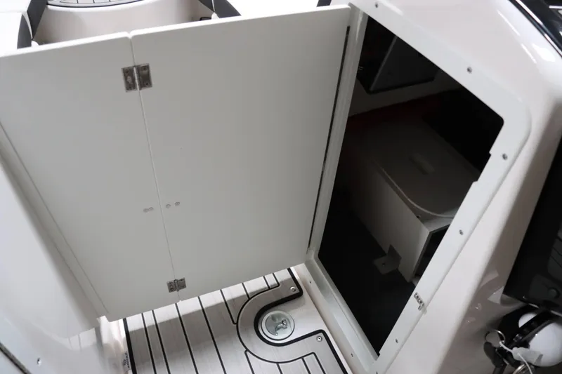 Slide: The Image of 2024 Yamaha Boats 222SD interior storage compartment with open door. - 22