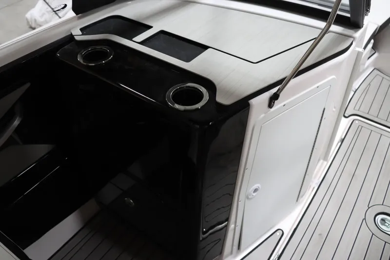 Slide: The Image of 2024 Yamaha Boats 222SD interior with sleek black and white design, featuring cup holders. - 23