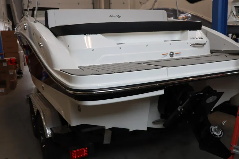 Slide: The Image of 2024 Sea Ray 210SPX boat rear view in a showroom. - 13