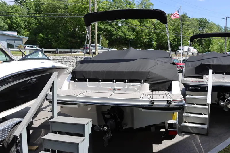 Slide: The Image of 2024 Sea Ray 210SPX boat with black cover, docked at marina. - 15