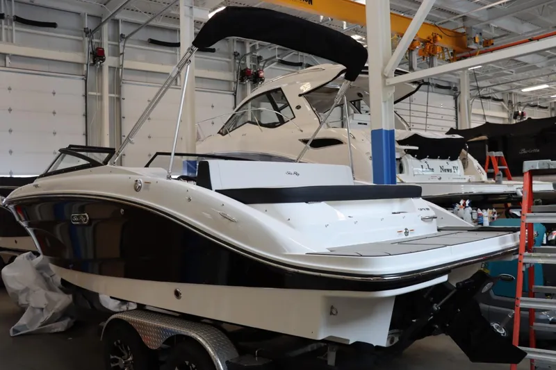 Slide: The Image of 2024 Sea Ray 210SPX boat in a showroom, rear view with black and white exterior. - 3