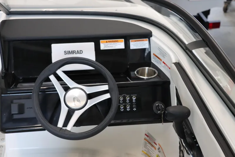 Slide: The Image of 2024 Sea Ray 210SPX boat dashboard with Simrad display and steering wheel. - 8