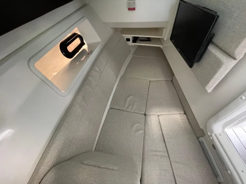 Slide: The Image of Interior cabin of 2024 Sea Ray 350 SLX with beige seating and a mounted TV. - 11