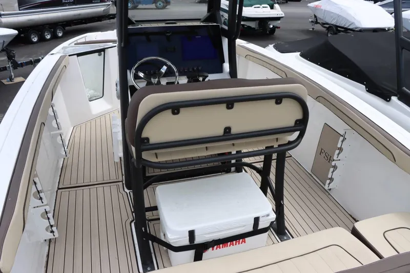 Slide: The Image of 2023 Yamaha Boats 255FSH SPORT E interior with helm, seating, and cooler. - 10