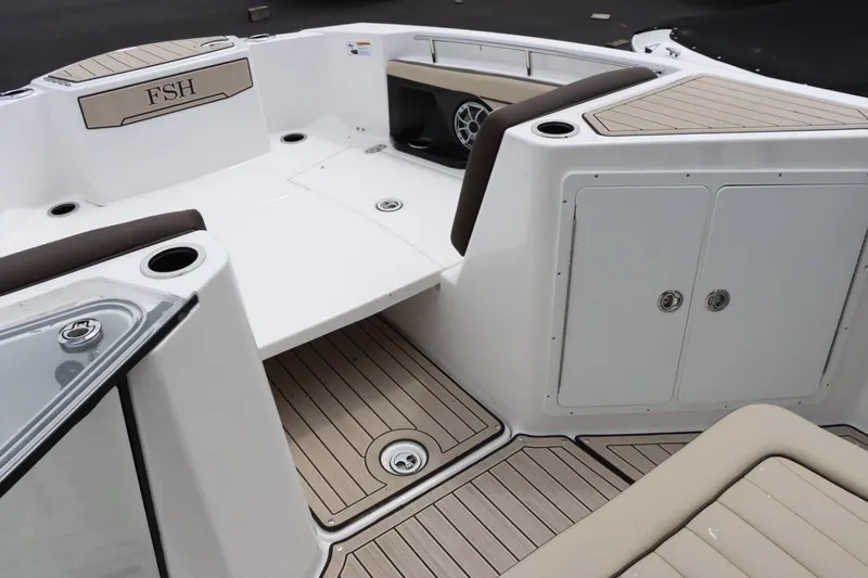 Slide: The Image of 2023 Yamaha Boats 255FSH SPORT E interior, featuring seating, storage compartments, and cup holders. - 13