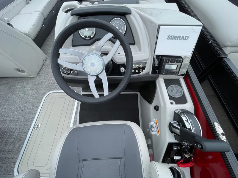 Slide: The Image of 2024 Barletta Cabrio 24UC boat helm with Simrad electronics and modern steering wheel. - 16
