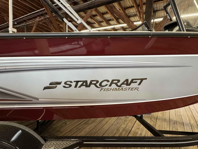 Slide: The Image of 2024 Starcraft Fishmaster 196 DC boat side view in a wooden dock. - 3
