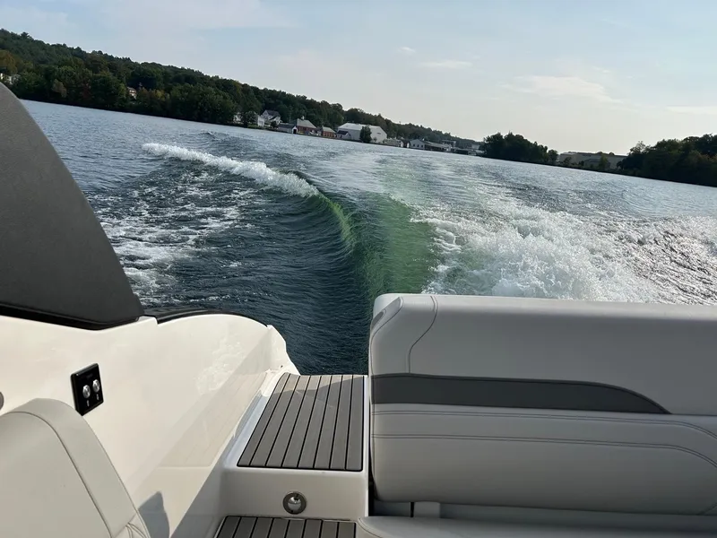 Slide: The Image of View from the 2023 Sea Ray 260SXS boat cruising on a serene lake. - 9